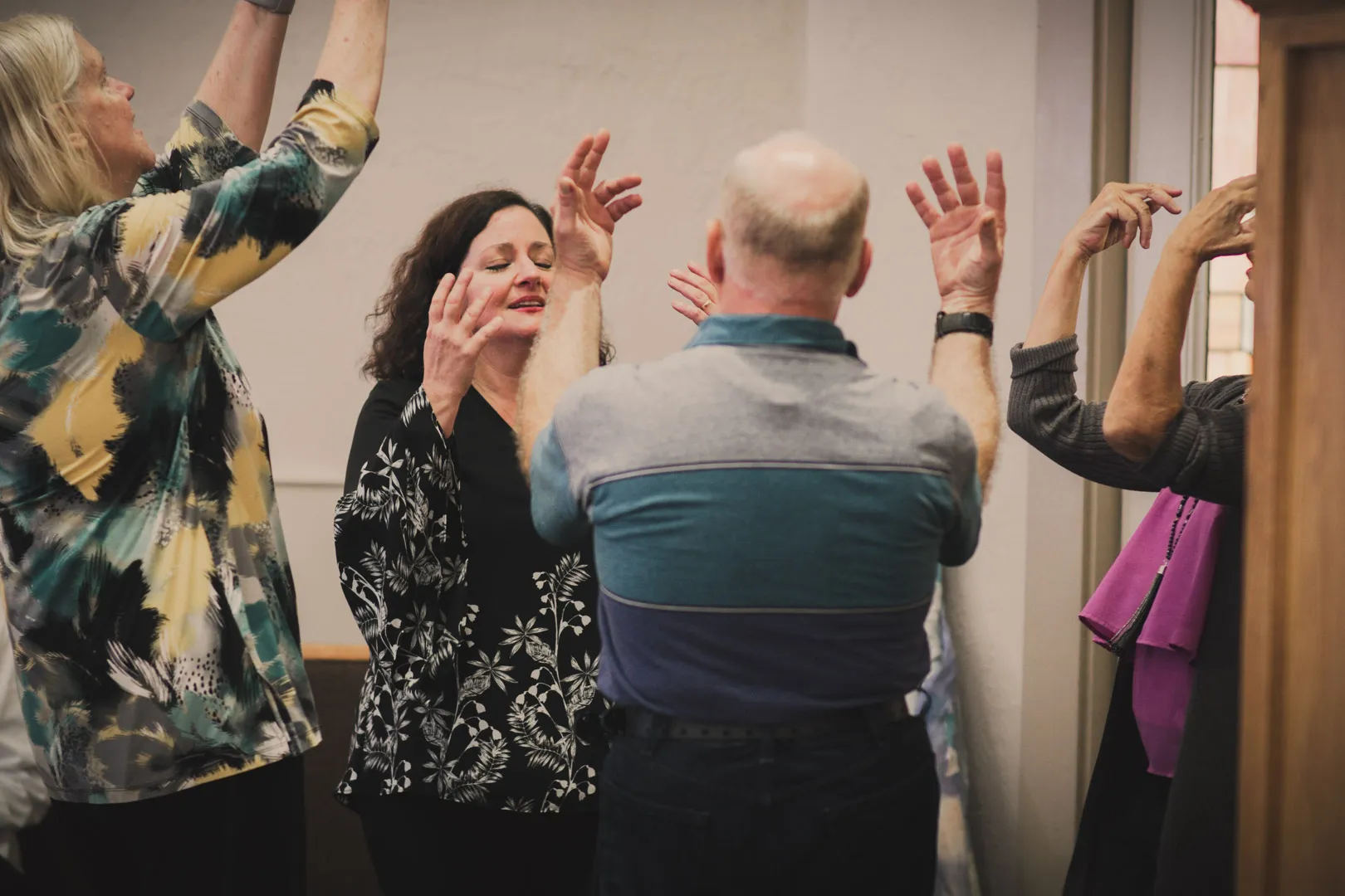 The congregation worshipping together with hands raised during a festival service.